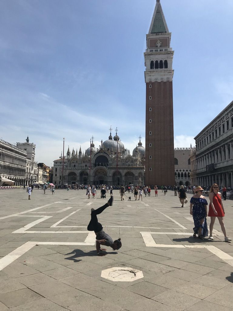 Josue in a handstand in the middle of Piazza San Marco, Venice, the campanile behind